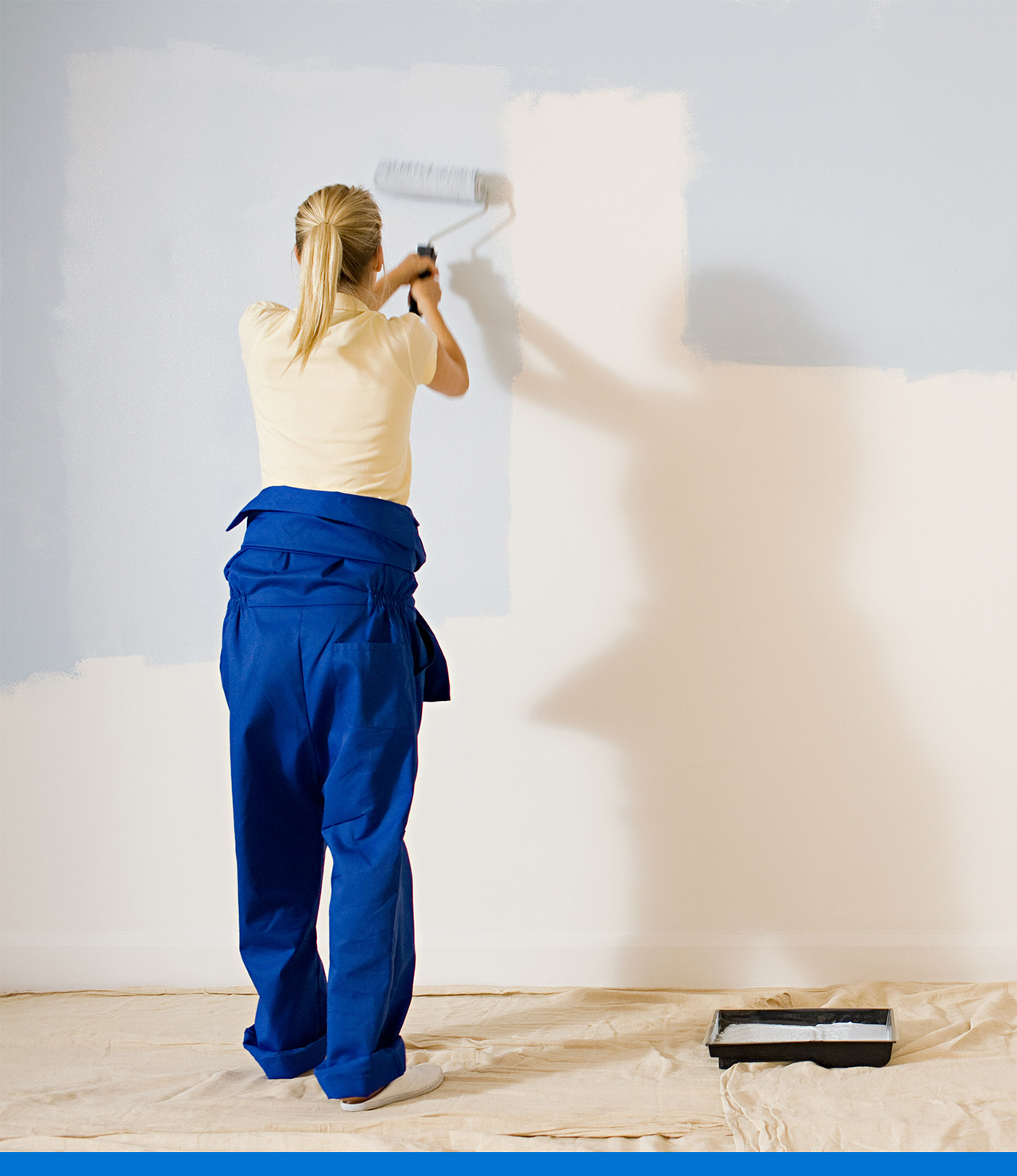 Usando un rodillo de pintura para pintar una pared