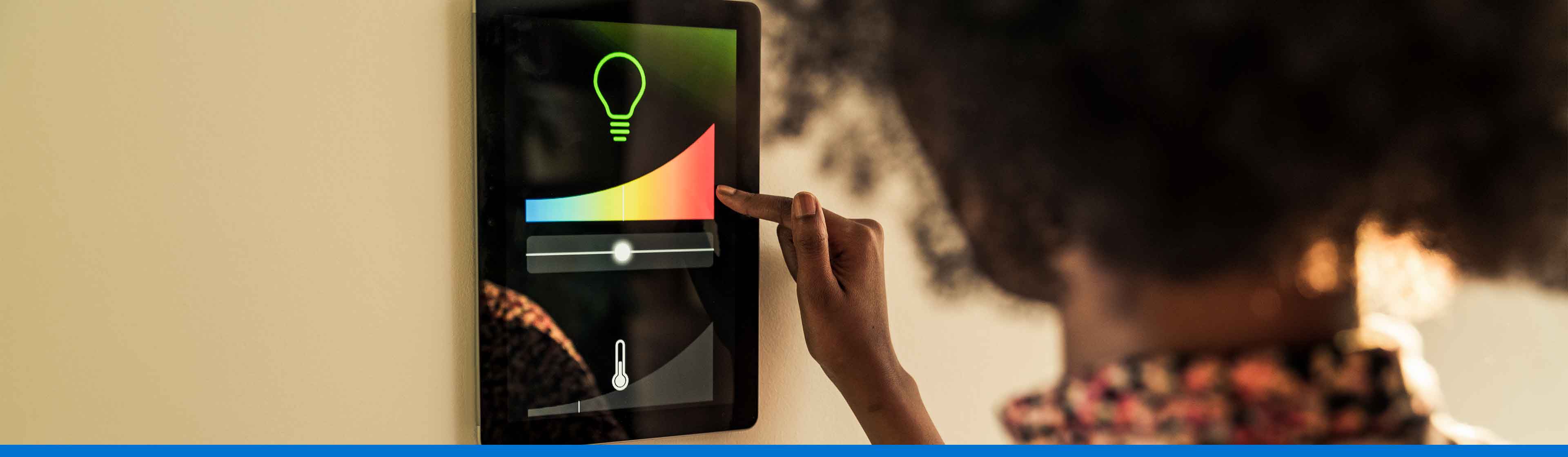 mujer controlando la temperatura y luces de su casa desde una tablet