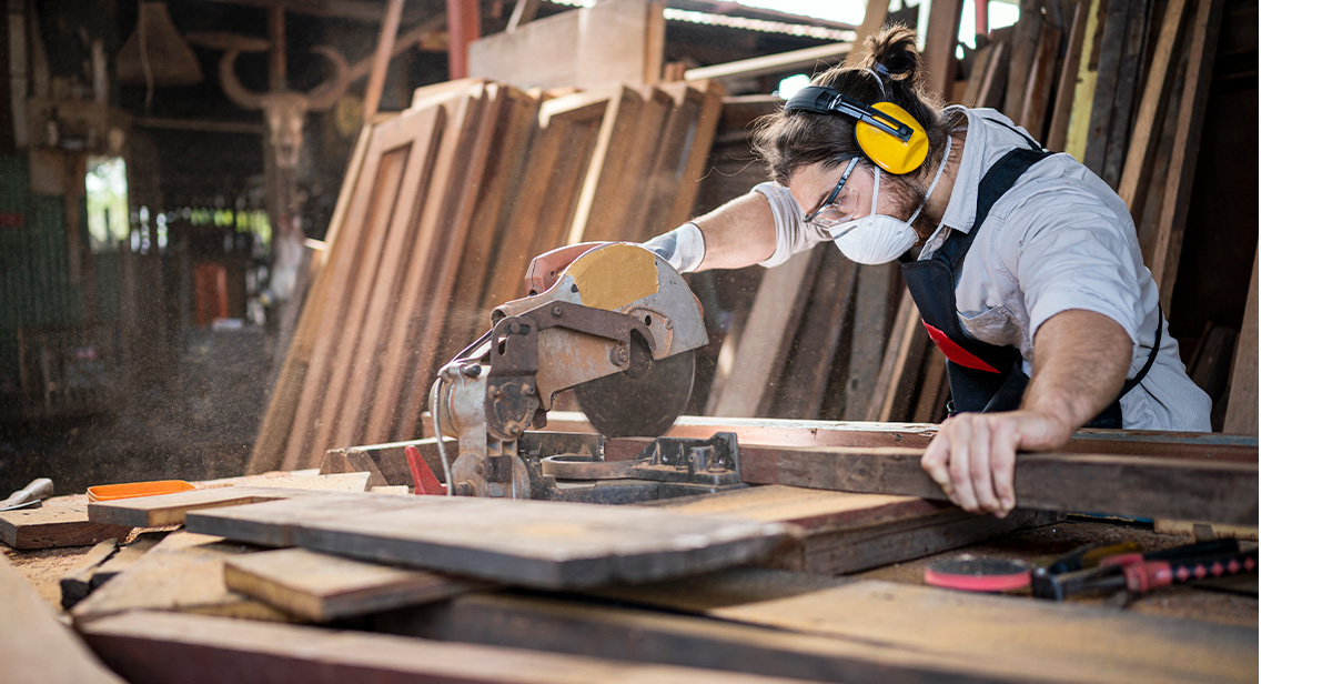 Hombre carpintero con máquina cortadora de madera eléctrica con equipos de  seguridad de protección en el taller de madera