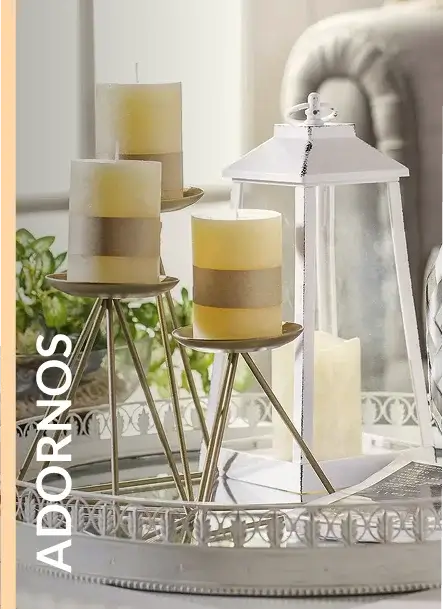 Velas decorativas sobre soportes dorados y un farol blanco clásico.